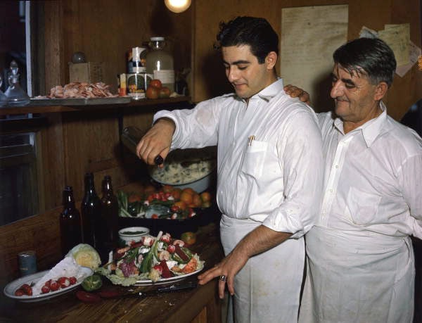 Louis Pappas and son Michael mixing Greek salad at famous Riverside cafe in Tarpon Springs, Florida.